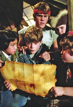 several young boys looking at a piece of paper