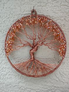 a wire tree hanging on the side of a wall