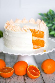 an orange cake with white frosting and sliced oranges