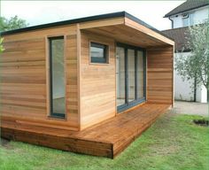 a small wooden house sitting on top of a lush green field