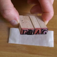 a person holding a rubber stamp with the word tag on it