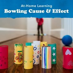 several different colored toilet paper rolls sitting on a table with the words at - home learning bowling cause & effect