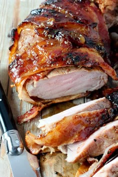 sliced pork on cutting board with knife and fork