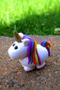 a small toy unicorn is sitting on the ground