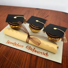 three graduation hats on top of a piece of cake