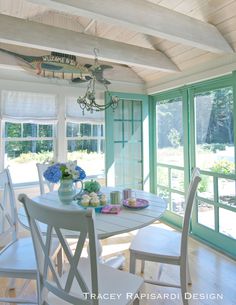 a table and chairs in a room with large windows