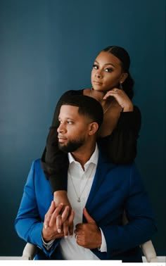 a man holding a woman on his back in front of a blue wall with the words,