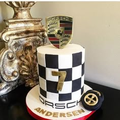 a white and black cake sitting on top of a table next to a gold trophy