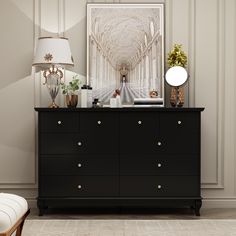 a room with a dresser, lamp and pictures on the wall above it that is decorated in white and gold