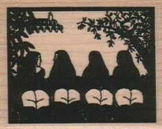 a wooden plaque with silhouettes of four women sitting on a bench under a tree