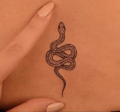 a woman's stomach with a snake tattoo on the back of her belly,