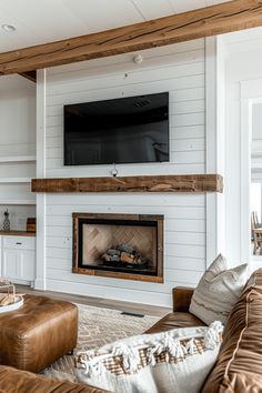 a living room with couches and a television mounted on the wall above it's fireplace