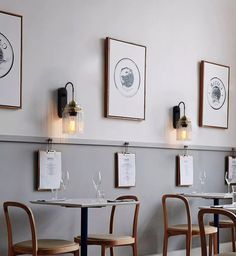 two tables and four chairs with menus on the wall