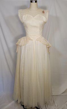 a white dress on a mannequin head stand