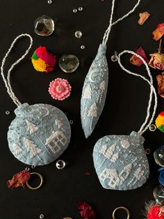 two stone ornaments are sitting on a table with beads and other decorations around them,