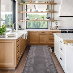 a kitchen with wooden cabinets and white counter tops, along with a rug on the floor