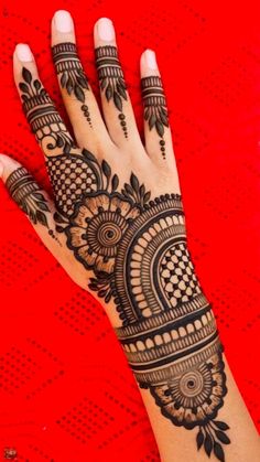 a woman's hand with henna tattoos on it