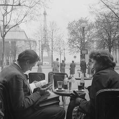 two people are sitting at an outdoor table