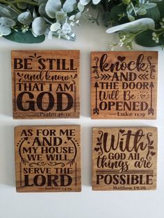 four wooden coasters with bible verses on them and flowers in front of them