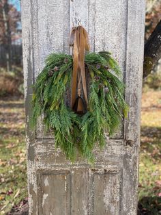 This rustic artificial Christmas wreath can be displayed long after the holiday season. Treat yourself or purchase for a Christmas, housewarming, or birthday gift. This design begins with an 18 inch natural grapevine base, however the completed look measures approximately 24 inches in length, 22 inches in width, and has a depth of approximately 6 inches.  A mixture of faux pine branches create interest and dimension, while the ribbon and rustic bell add a touch of old fashioned charm to the rustic aesthetic. I would recommend hanging under a covered porch where the wreath will be protected from the elements or indoors for longevity. For more holiday wreaths, click below. https://www.etsy.com/shop/TerrisLaughingTree?ref=seller-platform-mcnav§ion_id=38273736 For specialty wreaths for all occ Neutral Christmas Wreath, Pine Wreaths, Winter Wreath For Front Door, Brown Ribbon, Artificial Christmas Wreaths, Scranton Pa, Neutral Christmas, Pine Wreath, Pinecone Wreath