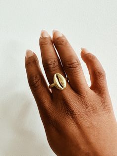 A beautiful brass cowrie shell with a lightly textured adjustable ring band. The cowrie shell represents Goddess protection, as well as symbolizes the power of destiny and prosperity. It is perfect worn alone or with a few of our stack rings.DETAILS:Available in brass or gold plated brass Adjustable Ring Band Ships with sample polishing cloth Packaged for gift giving *Sold individually, not a set. Gold Toe Ring Jewelry For Beach, Gold Toe Ring For Beach, Gold Shell Rings For Beach, Adjustable Open Ring Jewelry For Beach, Adjustable Open Ring Jewelry For The Beach, Adjustable Midi Rings For Beach, Adjustable Gold Shell Ring, Handmade Gold Rings For Beach, Handmade Gold Rings For The Beach