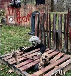 an outdoor area with wooden pallets and fake skeletons