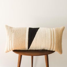 a black and white pillow sitting on top of a wooden table