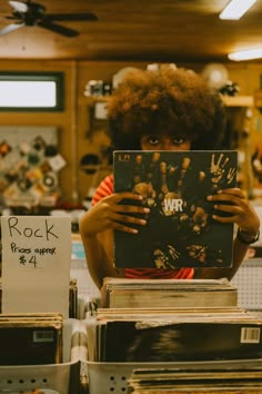 a woman holding up a record in front of her face with the words rock on it