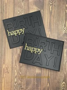 two black and gold birthday cards on wooden background