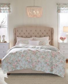 a bedroom with a bed, dressers and two lamps on the side of it