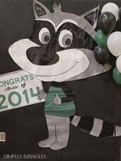 a raccoon holding balloons and a sign that says congrats class of 2011