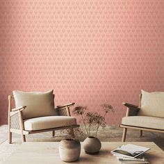 two chairs sitting next to each other in front of a wall with pink and white designs