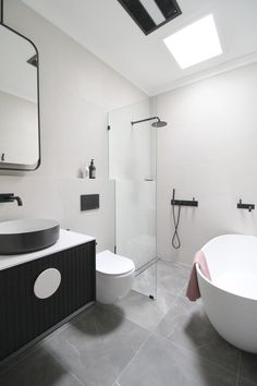 a bathroom with a large white tub next to a walk in shower and a toilet