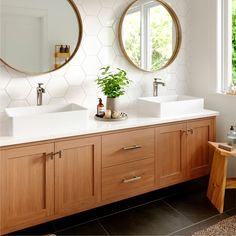 a bathroom with two sinks and mirrors on the wall