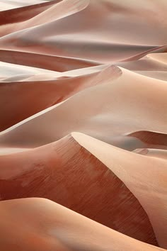 sand dunes in the desert with no people on them, and one person walking through it