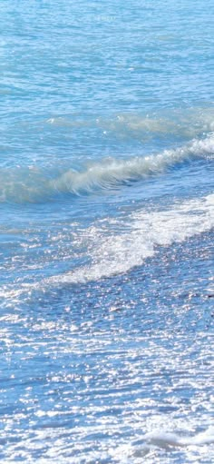 a man is walking along the beach with his surfboard