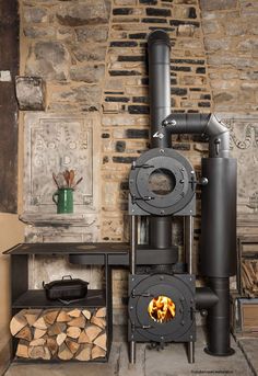 a black stove sitting next to a pile of wood