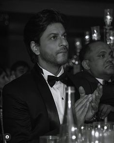 two men in tuxedos sitting at a table