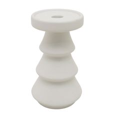 a white vase sitting on top of a table