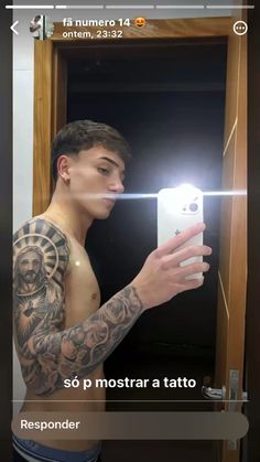 a man is taking a selfie in the mirror with his cell phone and tattoos on