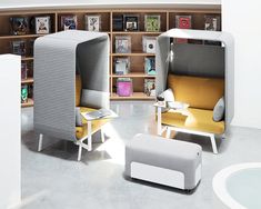 a room with some chairs and bookshelves inside of it on the floor next to a table