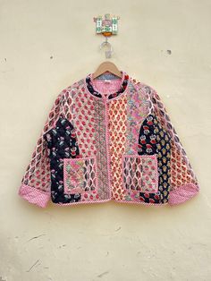 a pink and black jacket hanging on a wall