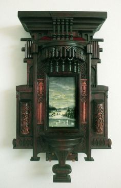 an ornate wooden clock with a painting on it