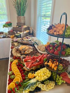 an assortment of fruits and pastries on a buffet table