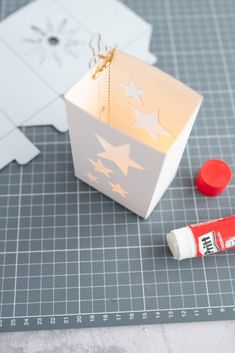 a white box with stars on it sitting next to some glue and a piece of paper