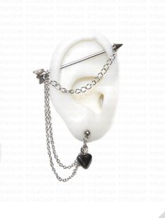 a white brooch with chain attached to it's ear and two black hearts