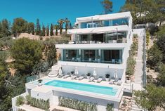 an aerial view of a house with a pool in the foreground and stairs leading up to it