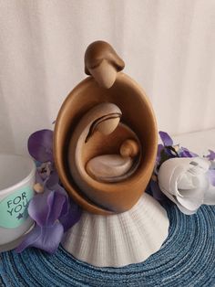 a ceramic figurine sitting on top of a table next to a cup and saucer