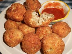 some fried food on a white plate with dipping sauce