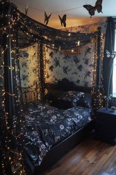 a bedroom decorated in black and white with fairy lights on the bed, butterflies flying overhead